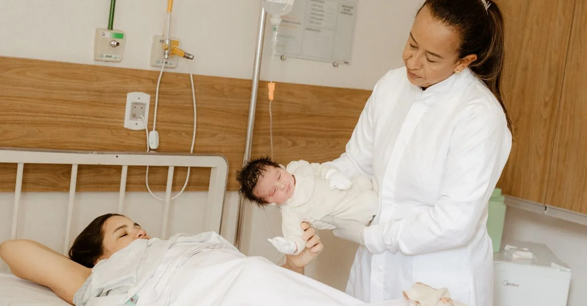 Un médico asiste a una nueva madre con su bebé recién nacido en un ambiente hospitalario.