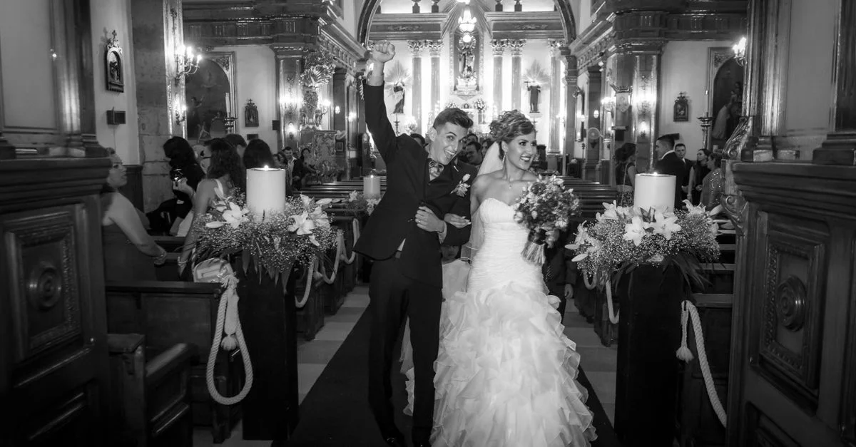Un couple de mariés joyeux célèbre après leur cérémonie de mariage dans une belle chapelle.