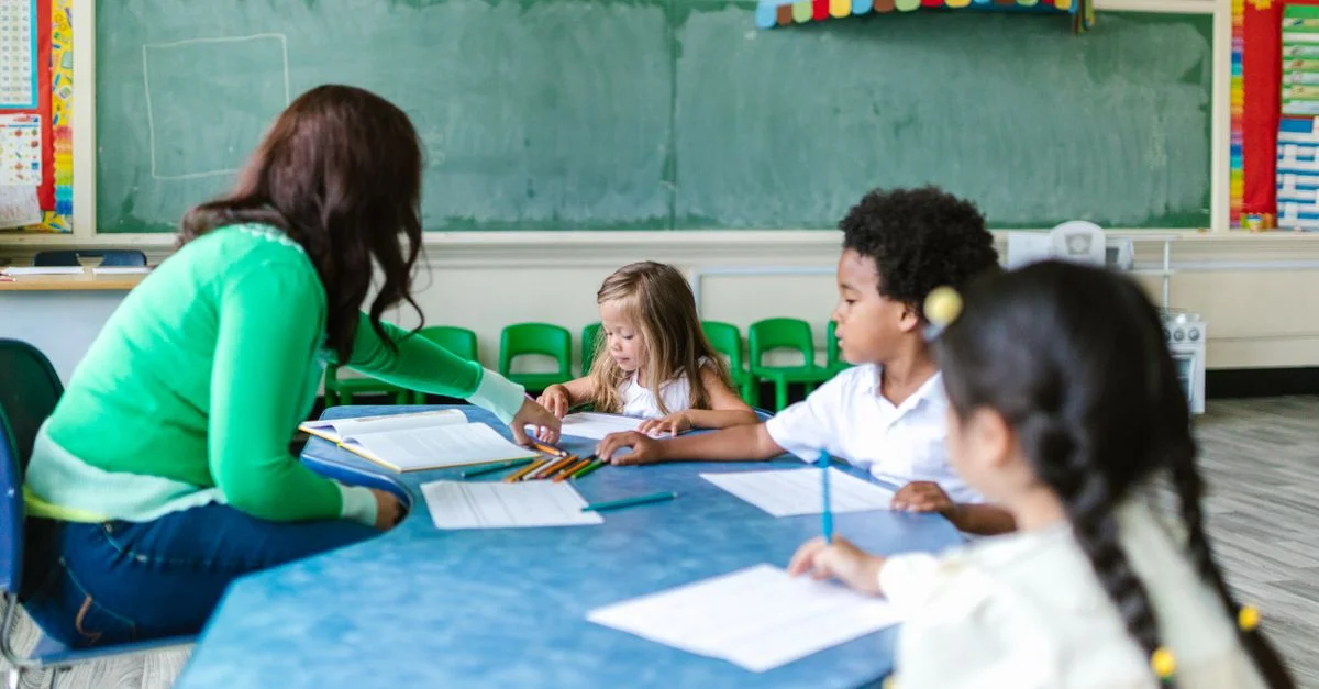 Niños en edad preescolar participando en el aprendizaje con un maestro en un entorno de aula.